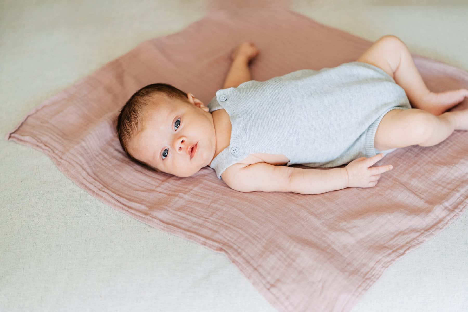 cute photo of baby laying on a blanket and yawning